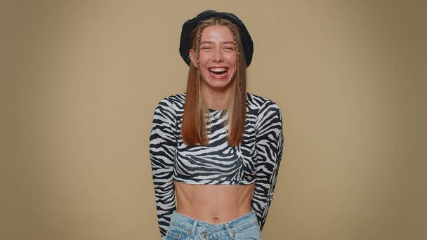 Lovely young woman laughing out loud after hearing ridiculous anecdote, funny joke, feeling carefree amused, positive people lifestyle. Adult stylish girl isolated on beige studio background indoors - Foto, imagen