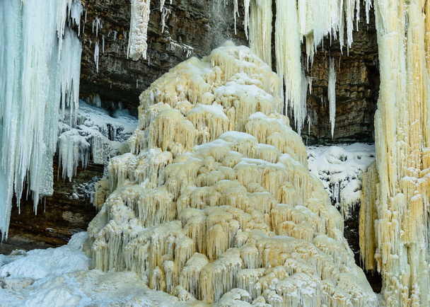 A peculiar, unusual beauty, ice stalagmite, consisting of many small icicles, in the limestone well of the Valaste waterfall, Estonia, which was formed during the period of severe winter frosts. - Valokuva, kuva