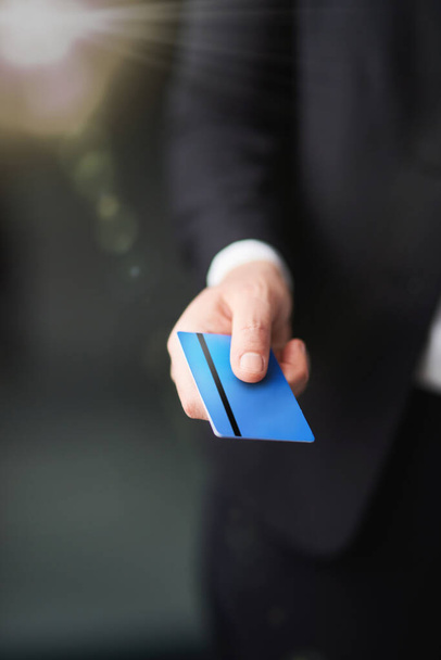 Managing his finances. a businessman holding out a credit card - 写真・画像
