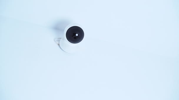 Isolated modern surveillance IP camera on a white wall. High quality 4k footage - Felvétel, videó