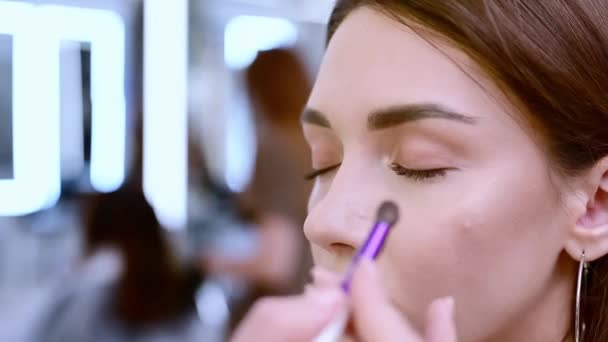 A beautiful brunette woman is tinted eyelids in a beauty salon. - Filmati, video
