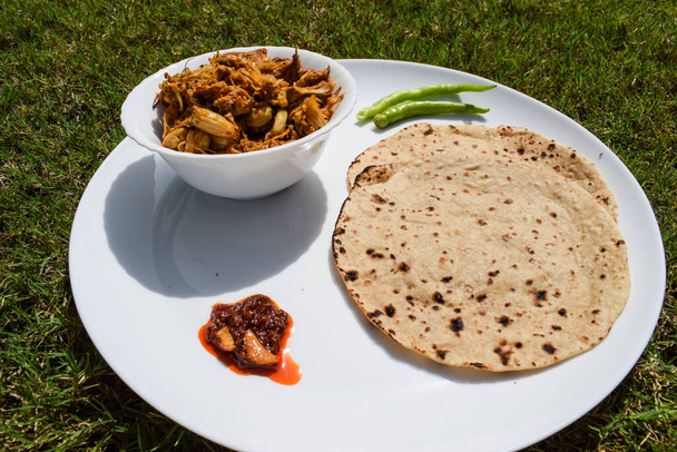 Simple and tasty Indian homemade lunch food item. Roti sabji lunch from India. Chapathi with Jackfruit curry. Jackfruit or Kathal ki sabji roti with pickle and raw green chilly - Foto, imagen