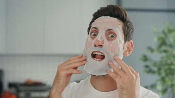 The person, applying a rejuvenating cosmetic mask to the face and with surprise and grimaces, having fun, enjoying himself. People and skincare concept - Séquence, vidéo