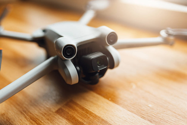Small size drone on wooden background, modern gadgets, aerial photography tool. - Foto, Imagen