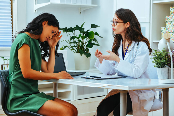 young female doctor explaining treatment to worried woman patient at health checkup - Foto, Bild