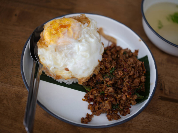 Pad Krapow MOO - Thai Basil Pork with Rice and fried Egg  background. Thai cuisine dish with minced  pork , basil, soy and oyster sauces. Thai Food Copy space - Foto, Imagen