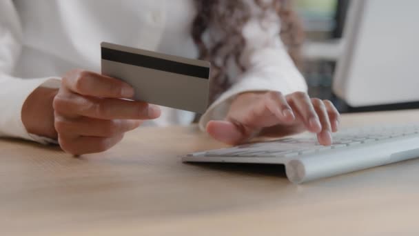 Close-up of female hands holding credit card entering data making purchases in online store paying for goods using computer banking application pays invoice secure payment uses fast money transfer - Video, Çekim