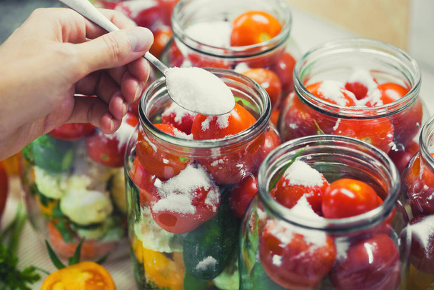 The process of preserving cucumbers and tomatoes for the winter. selective focus - Foto, Imagem