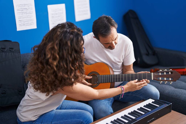 Man and woman musicians having classical guitar lesson at music studio - Zdjęcie, obraz