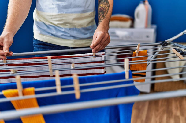 Joven pelirrojo colgando ropa en tendedero en la lavandería - Foto, Imagen