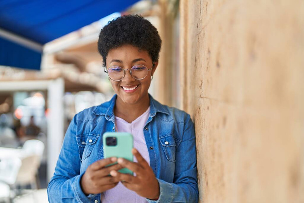 African american woman smiling confident using smartphone at street - Zdjęcie, obraz