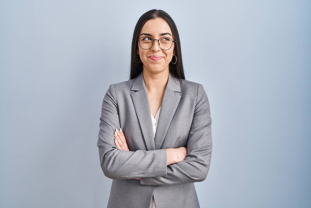 Hispanique femme d'affaires portant des lunettes souriant regardant vers le côté et regardant loin en pensant.  - Photo, image