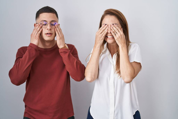 Mother and son standing together over isolated background rubbing eyes for fatigue and headache, sleepy and tired expression. vision problem  - Φωτογραφία, εικόνα