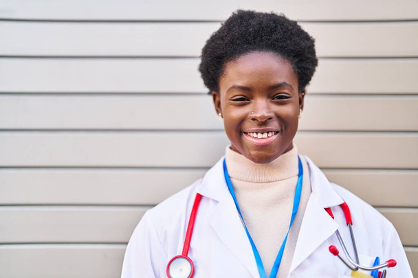 Afričanky americká žena nosí lékařskou uniformu stojící na ulici - Fotografie, Obrázek