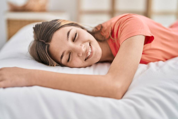 Rozkošná dívka s úsměvem jistý ležící na posteli v ložnici - Fotografie, Obrázek