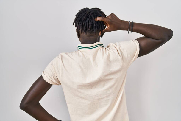 Afrikai férfi raszta áll elszigetelt háttér hátrafelé gondolkodás kétség kezét a fejre  - Fotó, kép