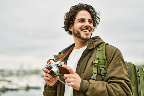 Marina Limanı 'nda klasik kamera kullanan yakışıklı İspanyol adam. - Fotoğraf, Görsel