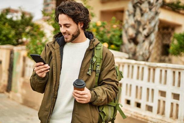 Knappe Spaanse man met smartphone in de stad - Foto, afbeelding