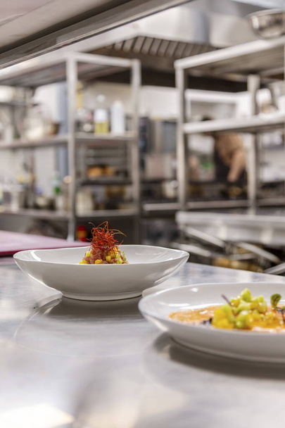 Dois pratos em placas de cerâmica brilhante estão na cozinha do restaurante na mesa de serviço. - Foto, Imagem