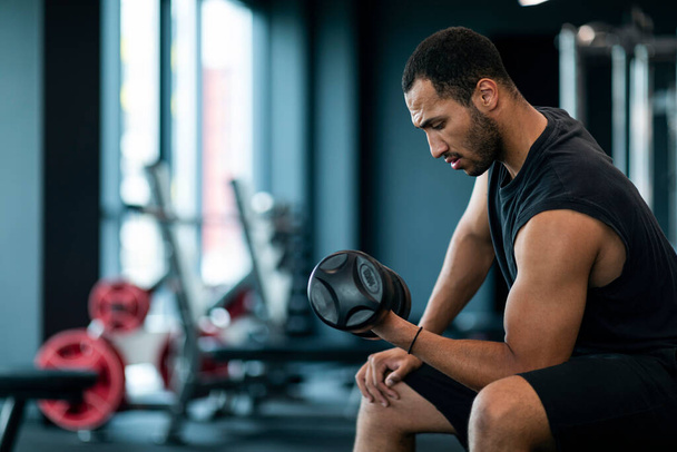 Sport Training. Muscular African American Guy Working Out With Dumbbell At Gym, Athletic Young Black Male Using Sport Equipment For Bodybuilding Workout At Modern Fitness Studio, Copy Space - Fotoğraf, Görsel