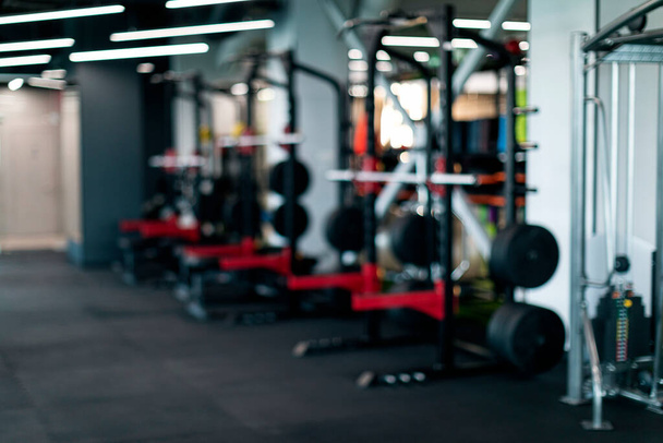 Blurred Background Of Modern Sport Club Interior With Heavy Weight Lifting Equipment, Set Of Steel Machines With Barbells At Gym, Different Training Tools For Bodybuilding Workouts, Copy Space - Foto, imagen
