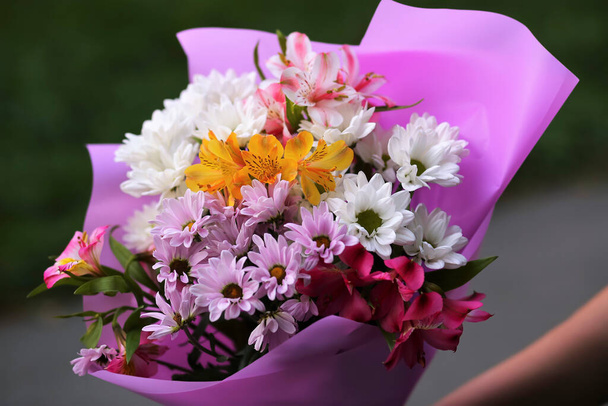 A bouquet of chrysanthemums (golden daisies) and  alstroemerias in violet wrapping - Zdjęcie, obraz