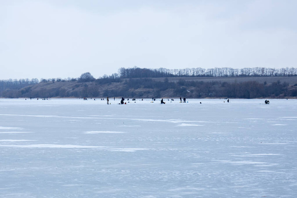 Many people on ice, winter fishing, frozen river in winter, ice fishing - Foto, Imagem