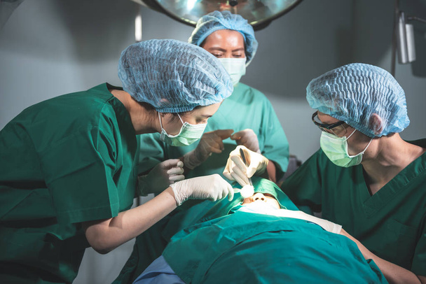 Asian team doctor Working in the operating room, Doing nose surgery on a female patients, to people health care and cosmetic surgery concept. - Fotografie, Obrázek
