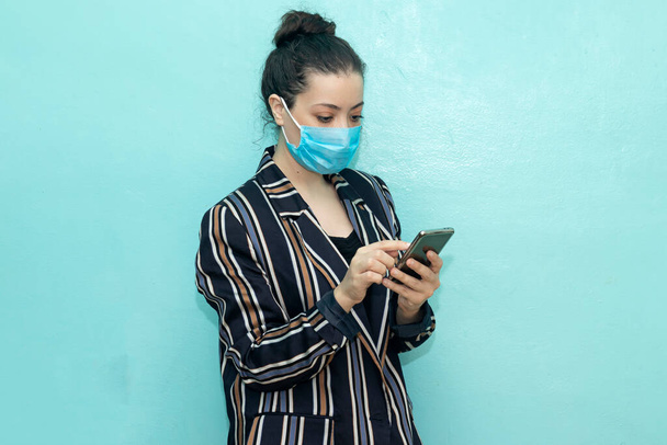 Mulher de negócios bonita enfrentar máscara protetora e usando smartphone durante a pandemia COVID-19  - Foto, Imagem