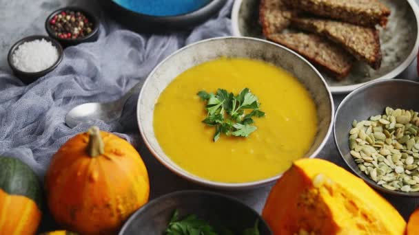 Pumpkin puree isoup in bowl over rusty stone background. Healthy diet food concept. Top view, flat lay - Footage, Video