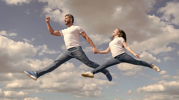 happy father and daughter jump in sky. active lifestyle. - Photo, Image