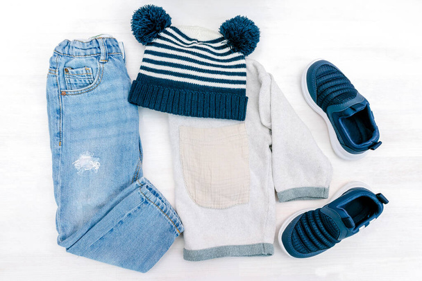 Jumper,hooded sweatshirt, jeans pants with sneakers,hat.Set of baby children's clothes and accessories for spring, autumn or summer on white background.Fashion kids outfit.Flat lay, top view,overhead. - Photo, Image