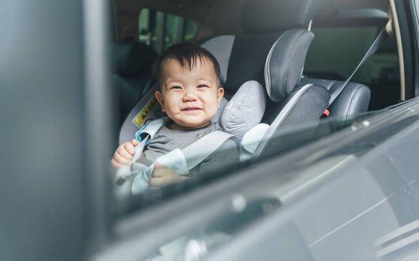 Cheerful Happy smiling Asian baby boy in safety car seat, Happy small toddler travel by car with family. - 写真・画像