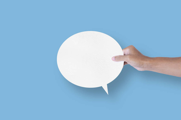 hand holding round white paper balloons speech bubbles isolated on light blue background communication bubbles - Fotó, kép