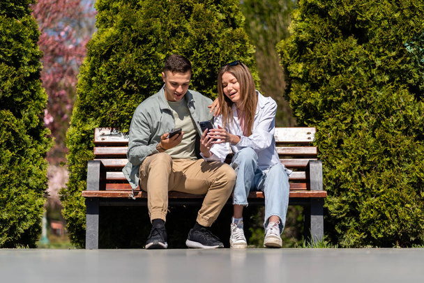 Dos amigos adolescentes felices hablando y mirándose en un parque
 - Foto, imagen