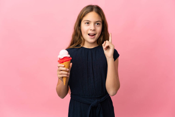 Παιδί με κορνέτα παγωτό πάνω από απομονωμένο ροζ φόντο σκέφτεται μια ιδέα που δείχνει το δάχτυλο προς τα πάνω - Φωτογραφία, εικόνα