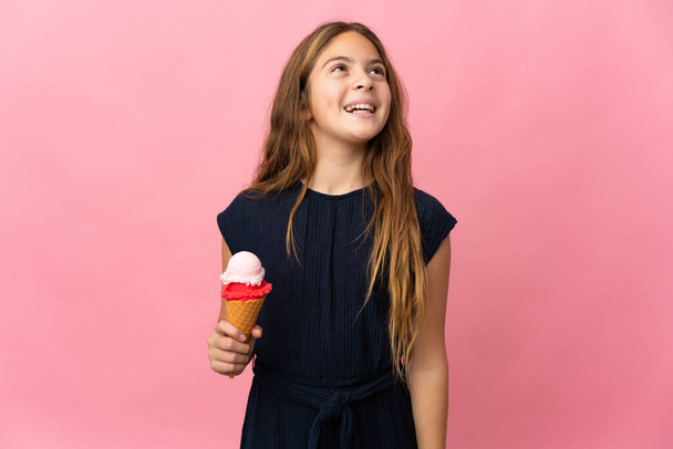 Child with a cornet ice cream over isolated pink background laughing - Foto, Imagem