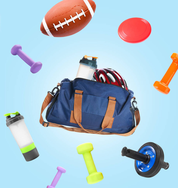 Flying sports bag and different equipment on light blue background - Foto, immagini