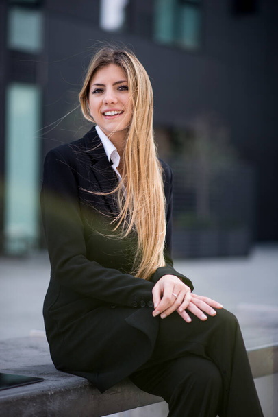 Young businesswoman sitting outdoor on a bench - Fotografie, Obrázek