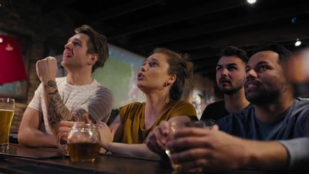 Group of friends cheering to soccer match in the pub. Shot with RED helium camera in 8K.  - Filmmaterial, Video