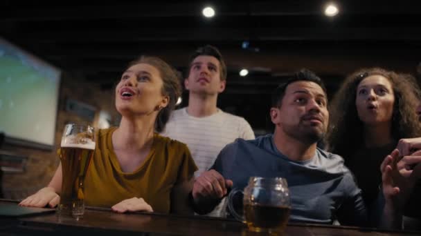 Group of friends cheering to soccer match in the pub. Shot with RED helium camera in 8K.  - Materiał filmowy, wideo