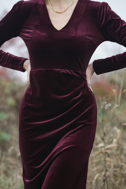 Autumn fashion outdoor portrait of young woman in purple red plush velvet midi dress.  - Photo, image