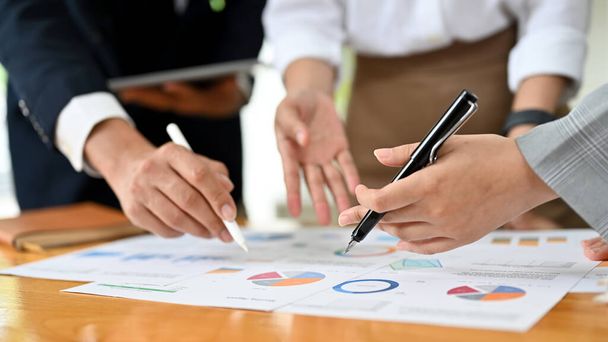 A professional financial analyst team is working and brainstorming to plan a business investment strategy. pen pointing on the report. cropped image - 写真・画像