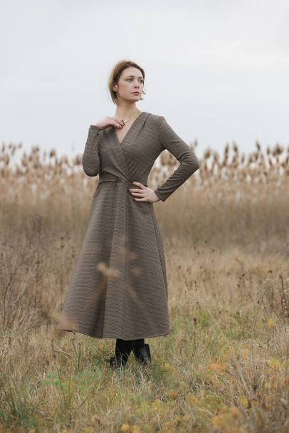 Fashion outdoor portrait of young woman in autumn brown long sleeve dress. - Zdjęcie, obraz