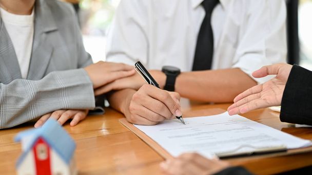 A loving couple is in a meeting with their real estate agent to sign the contract agreement for their new home. cropped image - Fotoğraf, Görsel
