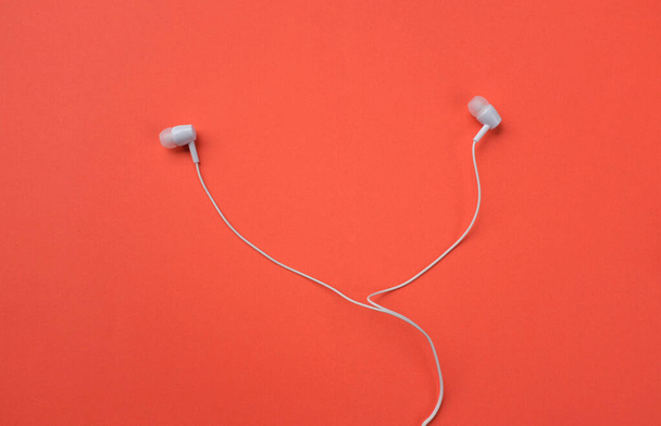 white music headphones ,earphones with headset on isolated bright orange background. Music concept. Top view - Φωτογραφία, εικόνα
