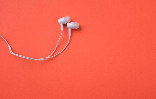 white music headphones ,earphones with headset on isolated bright orange background. Music concept. Top view - Φωτογραφία, εικόνα