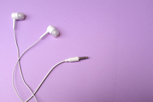white music headphones ,earphones with headset on isolated bright purple pastel background. Music concept. flat lay - Φωτογραφία, εικόνα