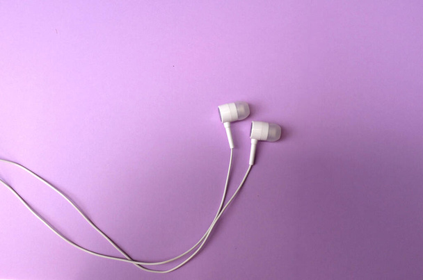 white music headphones ,earphones with headset on isolated bright purple pastel background. Music concept. flat lay - Valokuva, kuva