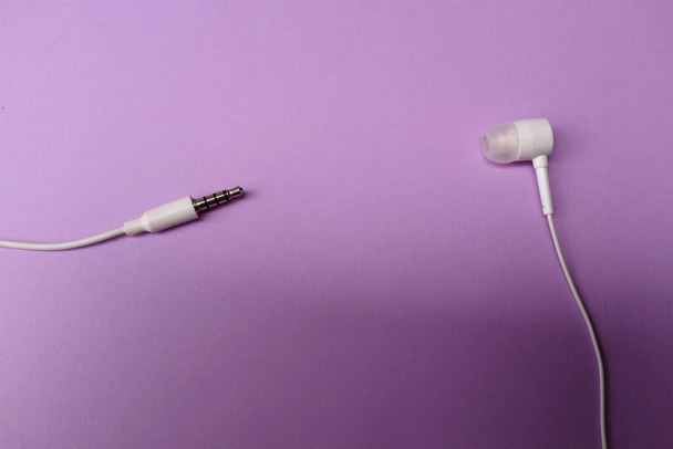 white music headphones ,earphones with headset on isolated bright purple pastel background. Music concept. Top view - Valokuva, kuva